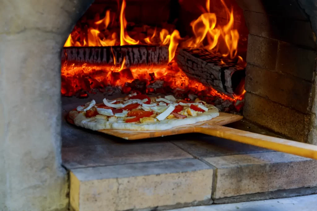 Putting a pizza into a pizza oven